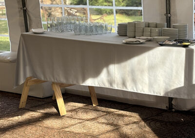 Mesa con vajilla dentro de carpa de eventos.